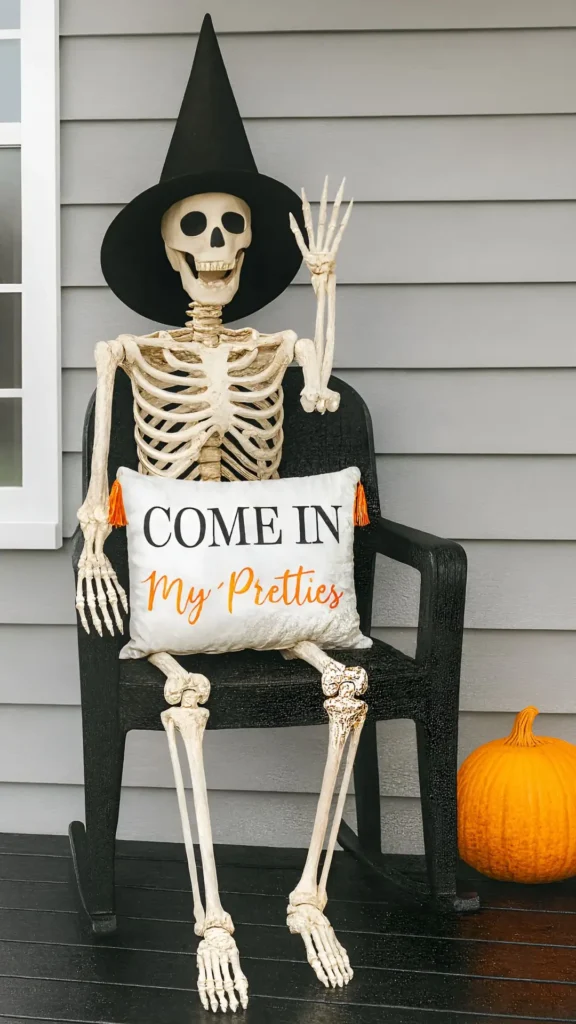 skeleton on the porch in a witch hat sitting in a chair