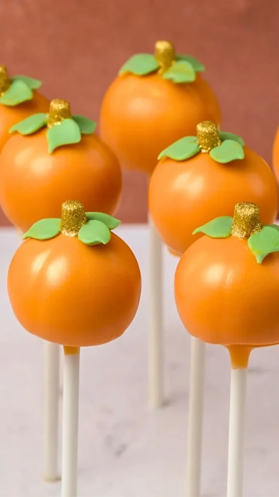 pumpkin cake pops standing in a holder, for Halloween