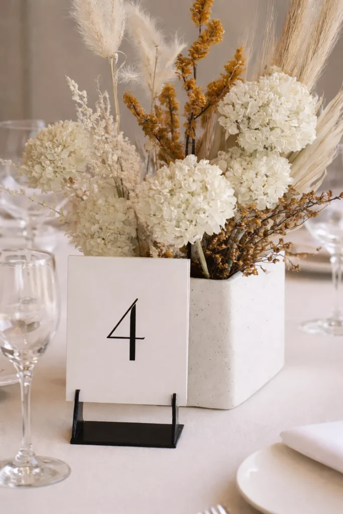 minimalist wedding table decor, table number with neutral floral arrangement